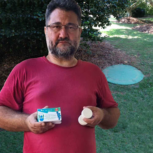 Homeowner holding Septifix box by septic tank lid